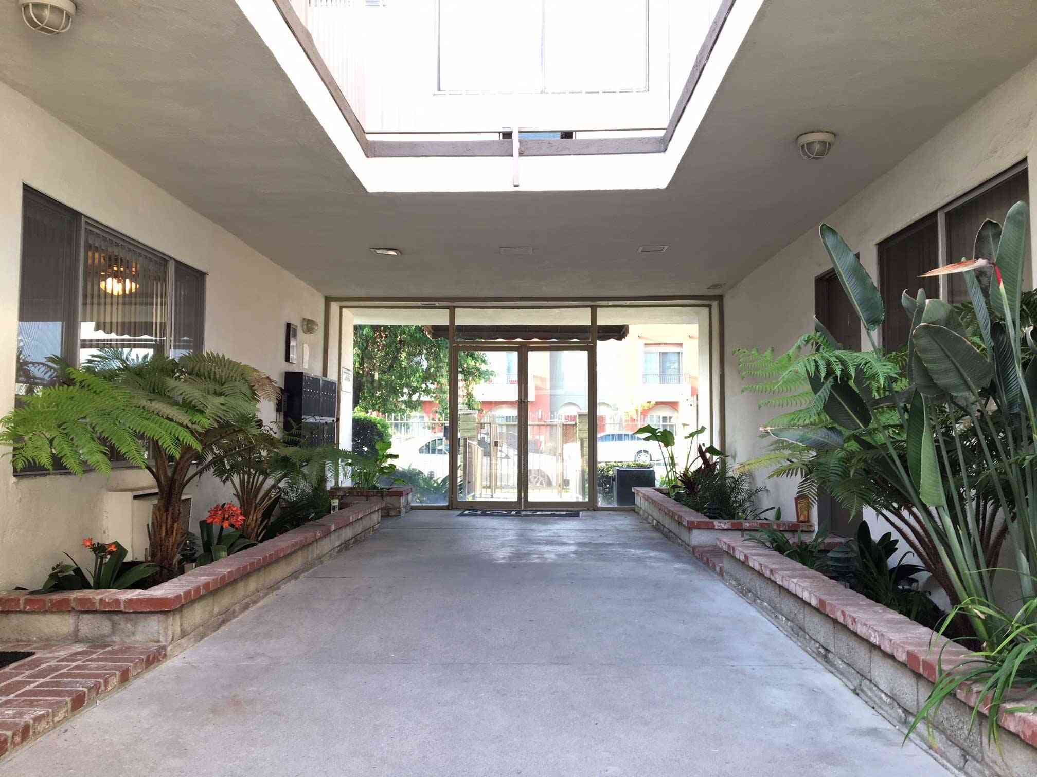 open air breezeway entrance with tropical landscaping