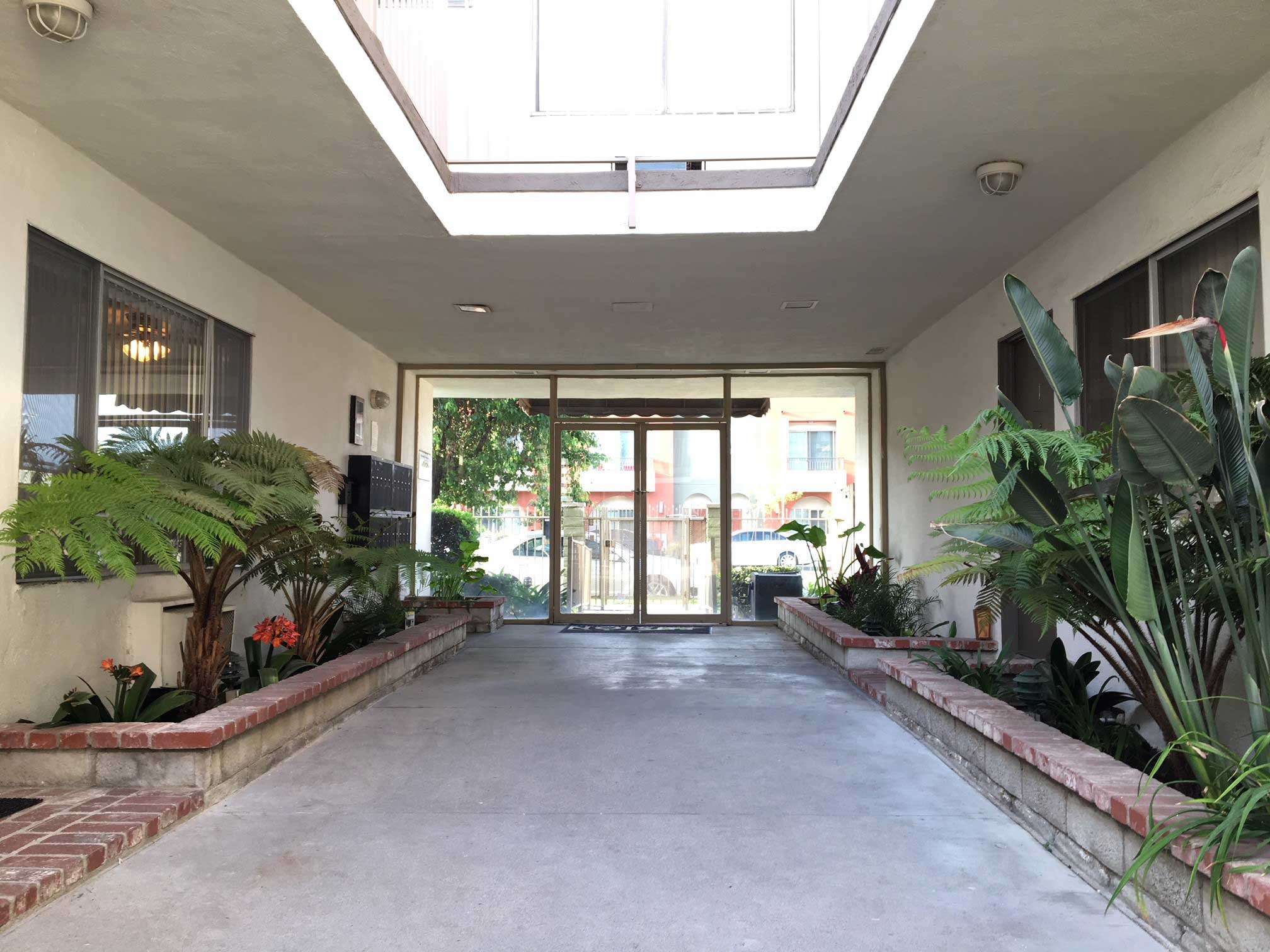 San Fernando Valley Collection open air breezeway entrance with tropical landscaping